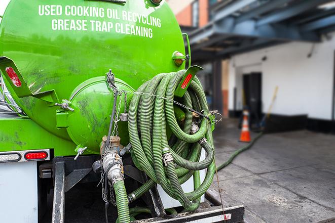 a technician pumping a grease trap in a commercial building in Pico Rivera, CA